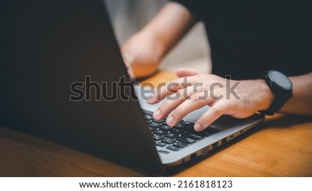 Closeup image of a business man's hands working and typing on laptop computer keyboard on office table.Business intelligence.