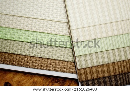 Samples of textured fabrics of different colors for the manufacture of fabric blinds for sun protection. Palette to choose from.