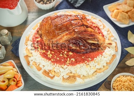 Arabic Cuisine; Egyptian oriental Fattah with white rice and crispy bread topped with seasoned garlic red sauce, crispy fried garlic and beef shank. Royalty-Free Stock Photo #2161830845