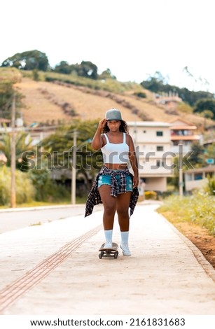 Black woman skateboarding on the street