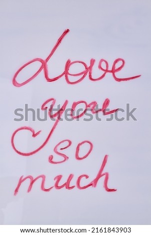Love you so much hand-written iscription isolated on white background. Romantic message, top view.