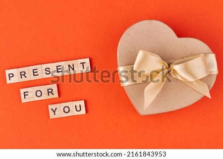 Beautiful heart-shaped gift box with bow on color background. Present for you.
