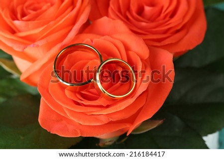 Wedding rings on wedding bouquet, close-up, on bright background