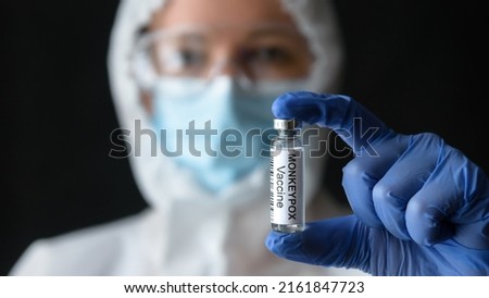 Monkeypox vaccine in doctors hand, scientist in personal protective equipment (PPE) shows bottle for shot from smallpox in lab. Concept of vaccine, monkey pox virus, treatment, health and injection. Royalty-Free Stock Photo #2161847723