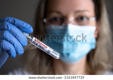 Monkey pox PCR test tube in doctors hand, medical worker in face mask shows swab collection kit for smallpox virus diagnosis and monkeypox research. Concept of monkey pox testing, care and health. Royalty-Free Stock Photo #2161847729