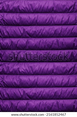 Texture of puffer, padded, down jacket. Background of urban winter outfit. Quilted pattern. Royalty-Free Stock Photo #2161852467