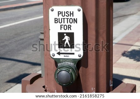 Pedestrian street crossing sign with button and arrow