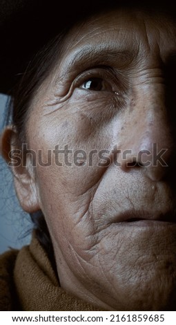 Close-up of an older woman, looking seriously at the camera. Royalty-Free Stock Photo #2161859685