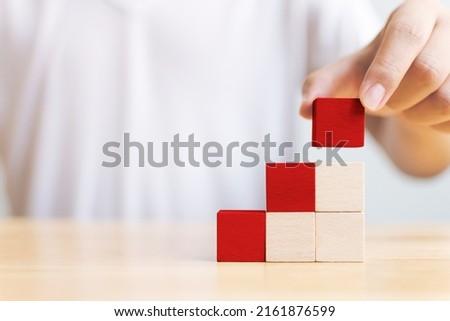 Hand holding red wood block on top step. Ladder career path concept for business growth success process Royalty-Free Stock Photo #2161876599