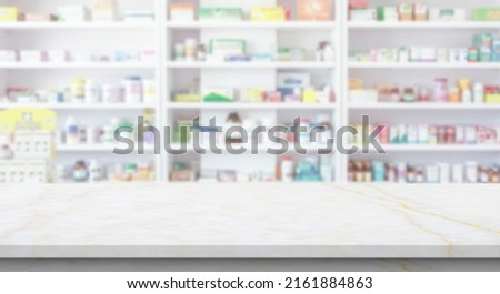 Empty white marble counter top with blur pharmacy drugstore shelves background Royalty-Free Stock Photo #2161884863