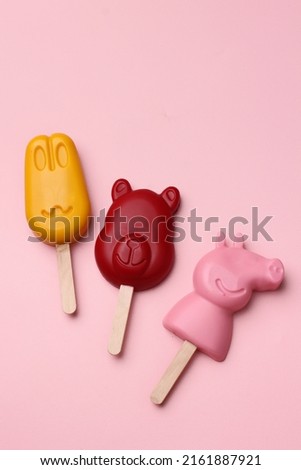 Children's toy in the form of an animated ice cream character on a pink background.