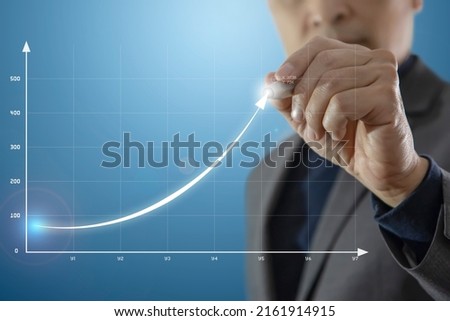 Businessman presenting business performance by drawing an exponential graph of business progress Royalty-Free Stock Photo #2161914915