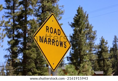 A bright yellow Road Narrows sign. Royalty-Free Stock Photo #2161915943