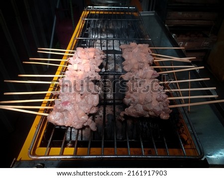 goat satay with 20 skewers still grilled on the stove against a wall background. This picture was taken at a restaurant in Batang, Central Java