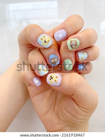 Hands with cute nail painted cartoon design. A new raising trend not only in Asia, but also around the world.
