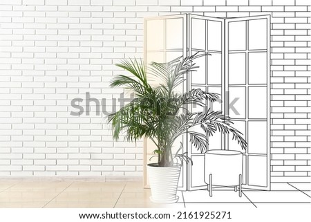 New interior of room with palm, folding screen and pouf near white brick wall