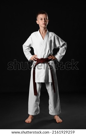 Boy in karategi on black background Royalty-Free Stock Photo #2161929259