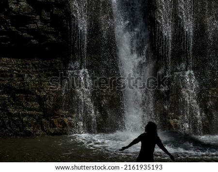 waterfall . Young girl tourist discover the beauty of earth. female  silhouette. woman with hands up.