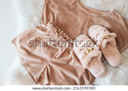Home slippers and cozy pajamas on a fluffy white plaid Royalty-Free Stock Photo #2161939383