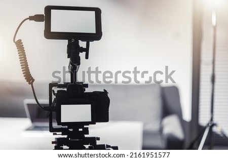 Modern Professional Digital Camera with External Display Recorder on a Tripod. Videography Industry.