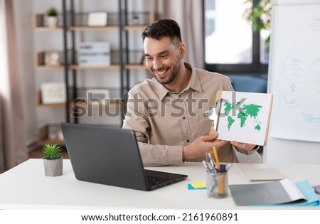 distance education, school and remote job concept - happy smiling male geography teacher with world map and laptop computer having online geography class at home office Royalty-Free Stock Photo #2161960891