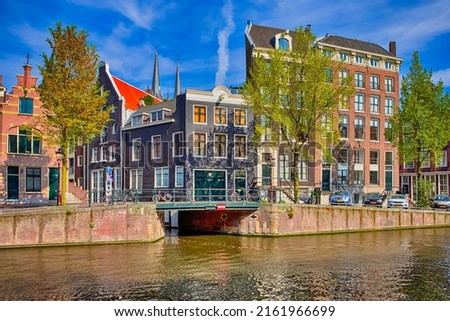 Daytime Romantic Amsterdam River Canal For Transportation and Boat Cruises For Guests and Visitors Along Arched Bridges in Amsterdam. Horizontal Shot Royalty-Free Stock Photo #2161966699