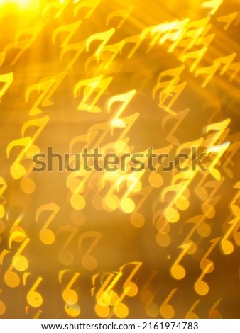 Golden note shape bokeh on brown background, Abstract yellow shining musical note shape bokeh. Vertical