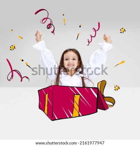 Joy and fun. Happy kid, little smiling girl stick out from big gift box isolated on gray background with pencil sketch and drawings. Concept of emotions, ideas, imagination, birthday party.
