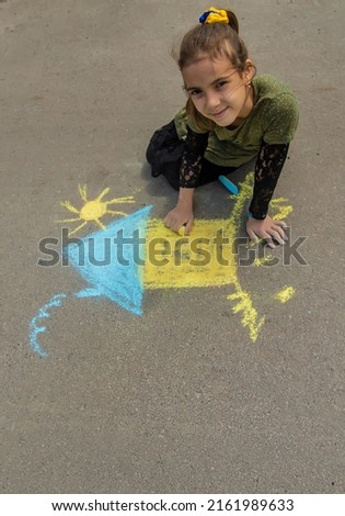 Children draw the Ukrainian flag house on the pavement. Selective focus. Kid.