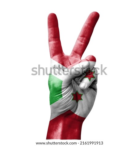 Hand making the V victory sign with flag of burundi