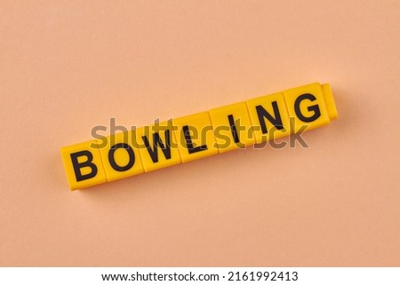 Black word bowling written on yellow cubes close up. Flat lay.