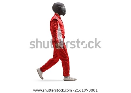 Full length profile shot of a racer in a red suit and black helmet walking isolated on white background Royalty-Free Stock Photo #2161993881