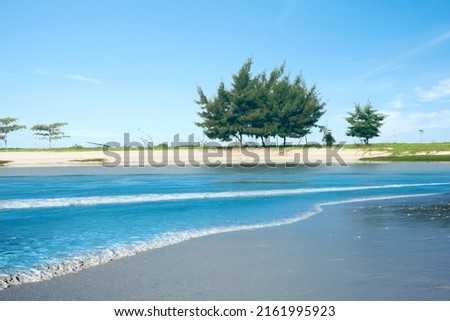 Sandy beach with the blue ocean and blue sky background