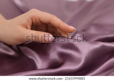 Woman touching smooth silky fabric, closeup view Royalty-Free Stock Photo #2161999885