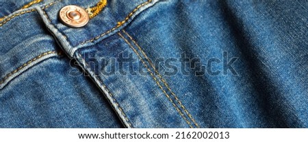 Zipper and buttons close-up detail of light blue jeans denim
