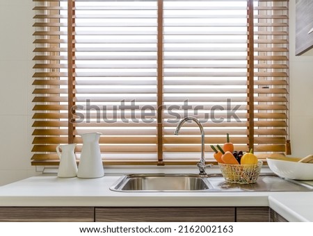 Sink in the modern kitchen, windows decorated with wooden blinds Royalty-Free Stock Photo #2162002163