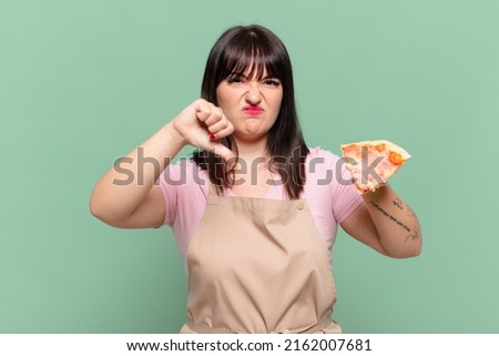 pretty chef woman angry expression and holding a pizza