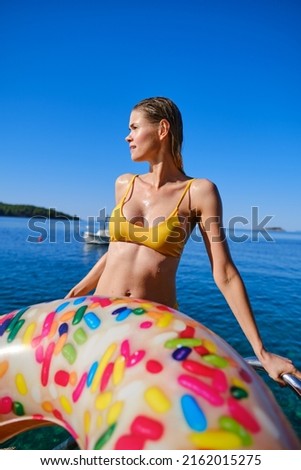 Happy smiling woman in bikini and sunhat on sea beach