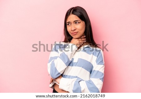 Young hispanic woman isolated on pink background suffers pain in throat due a virus or infection.