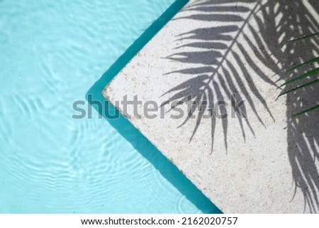 Swimming pool top view background. Water ring and palm shadow on travertine stone Royalty-Free Stock Photo #2162020757