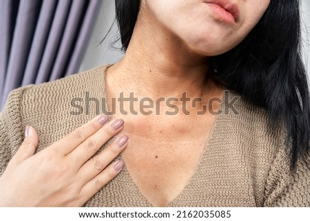 closeup woman having a problem with neck wrinkles, dark skin, aging process concept   Royalty-Free Stock Photo #2162035085