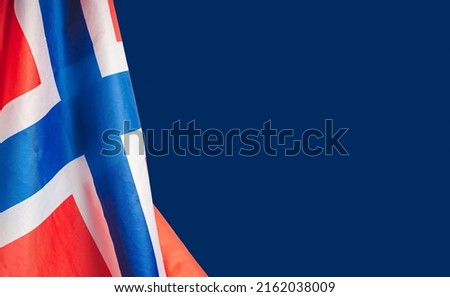 Close-up of the Norway flag on a blue background. Space for text. Close-up photo