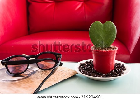 Heart-shaped tree in a pot with a coffee morning on the red sofa