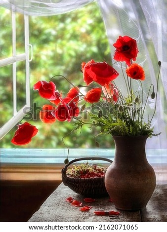 Still life with bouquet of red poppies and strawberry