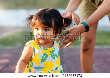 asian happy little girl play in park with mother hand in hand