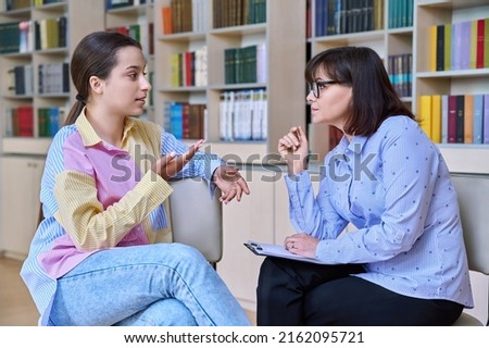 Psychologist, high school behavior counseling teenage student in library Royalty-Free Stock Photo #2162095721
