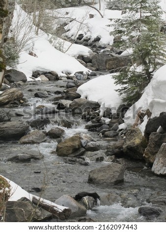Switzerland winter stream over rocks Royalty-Free Stock Photo #2162097443