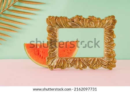 Summer arrangement made of watermelon slices, palm leaves and retro picture frames. Minimal vintage concept.