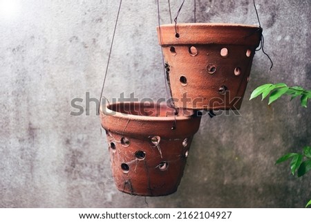 An old clay pot hangs beside an old wall. vintage design ideas Old tribal clay pots, old walls Royalty-Free Stock Photo #2162104927