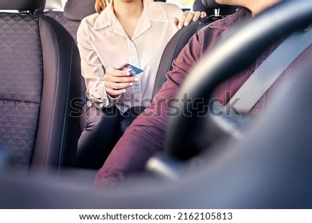 Taxi and card payment. Customer paying cab fare. Woman giving money to driver. Transaction security, scam or fraud concept. Passenger purchase ride service or business commute. Bank credit and wallet. Royalty-Free Stock Photo #2162105813